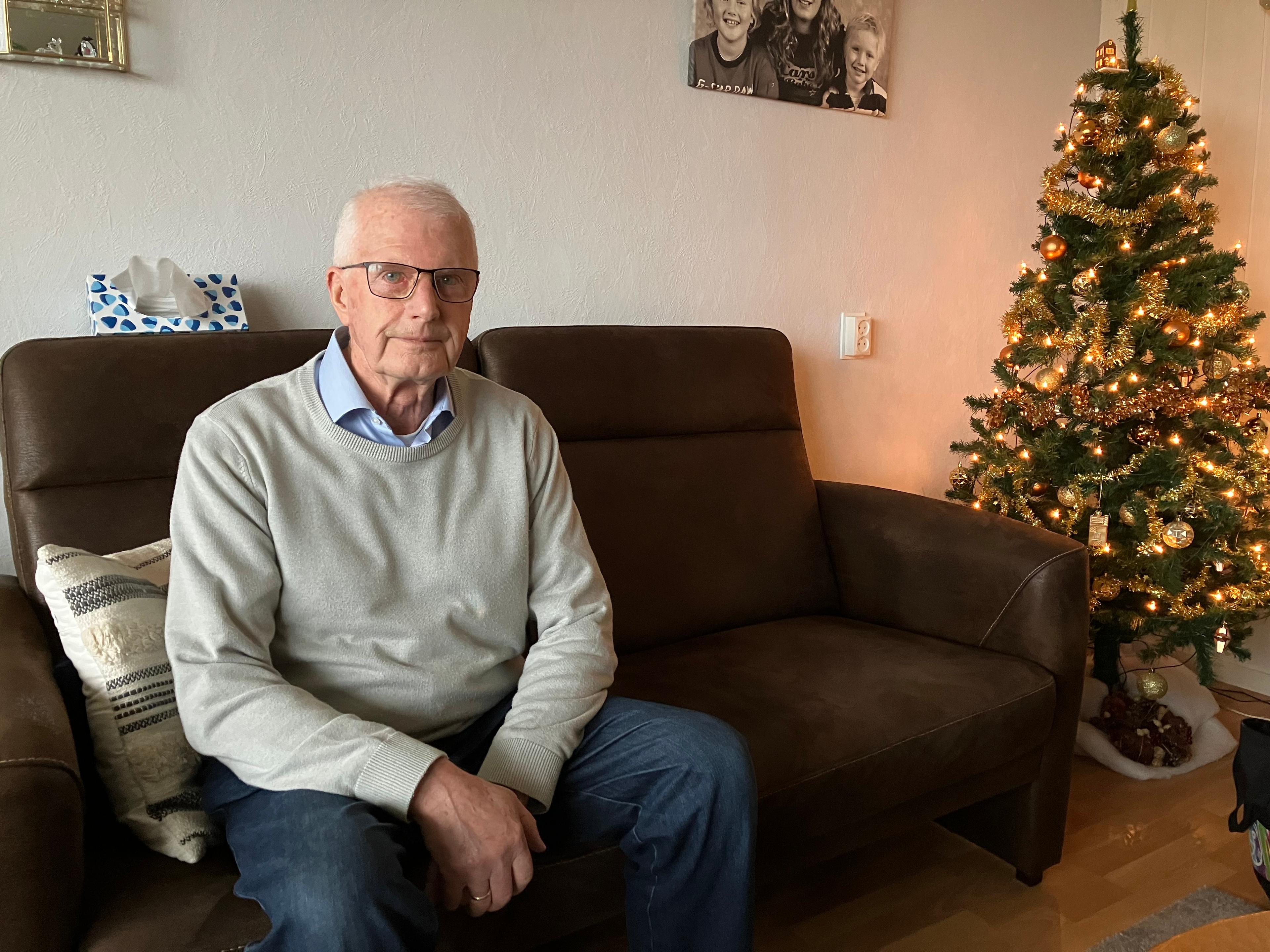 Schalk van Eijk op de bank naast de kerstboom