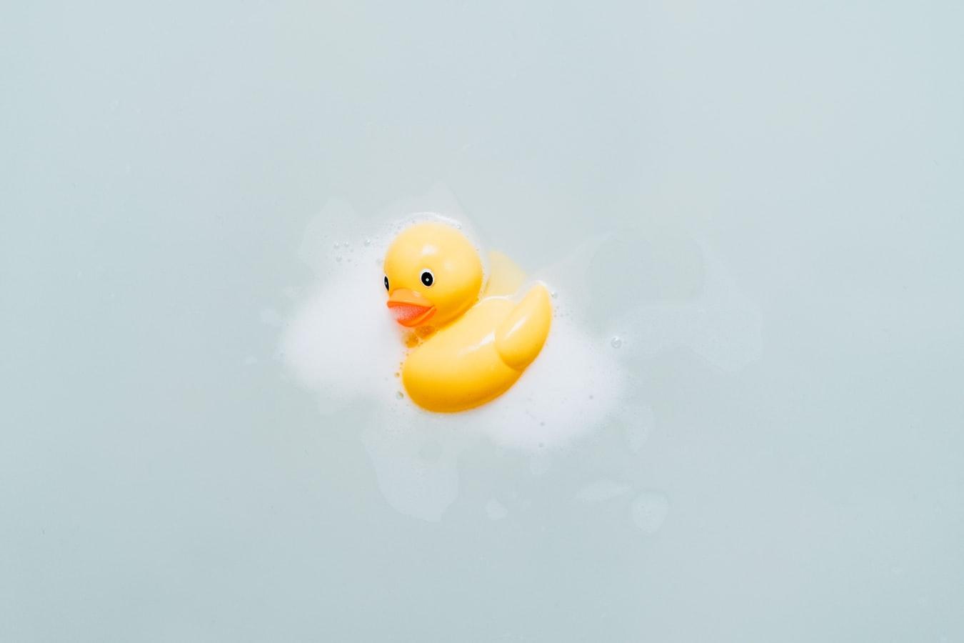 Gele badeend in het water met badschuim