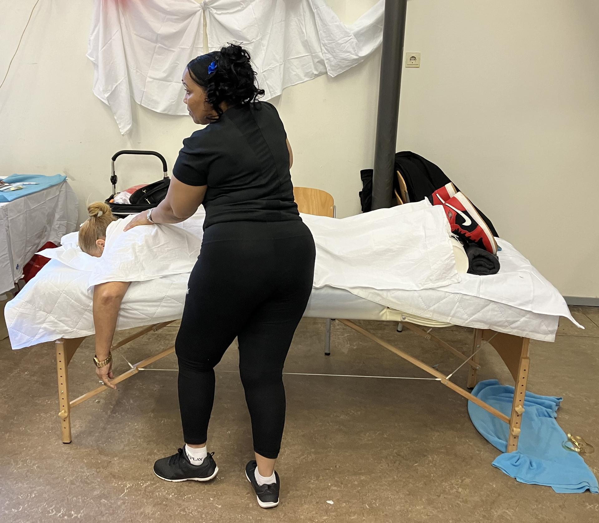 Vrouw geeft massage aan vrouw die ligt op tafel