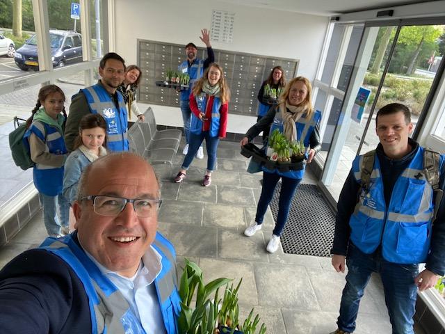 Groepsfoto met Mohamed in blauwe hesjes