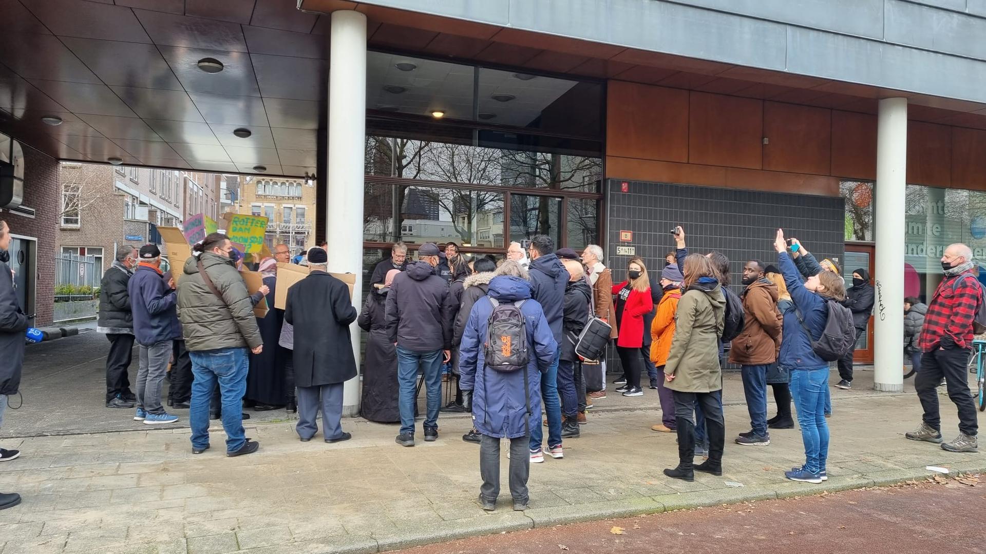Mensen protesteren voor het kantoor van Woonstad