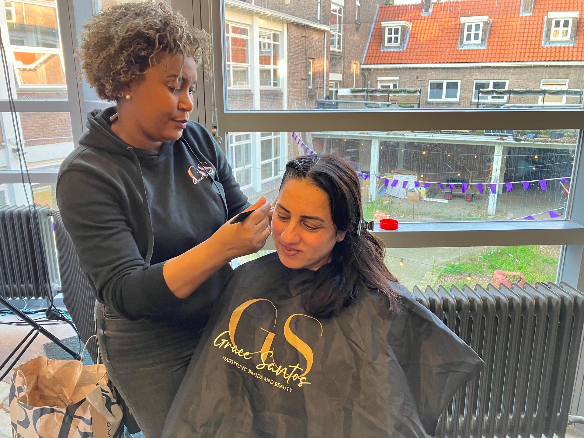 Vrouw is het haar van andere vrouw aan het braiden