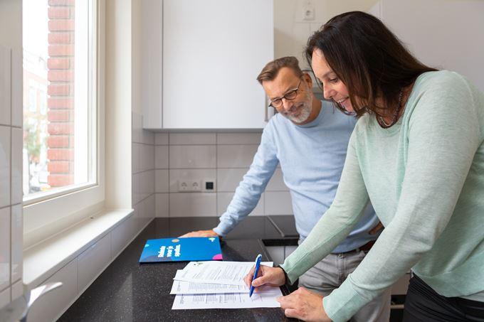 Een man en vrouw ondertekenen een huurcontract