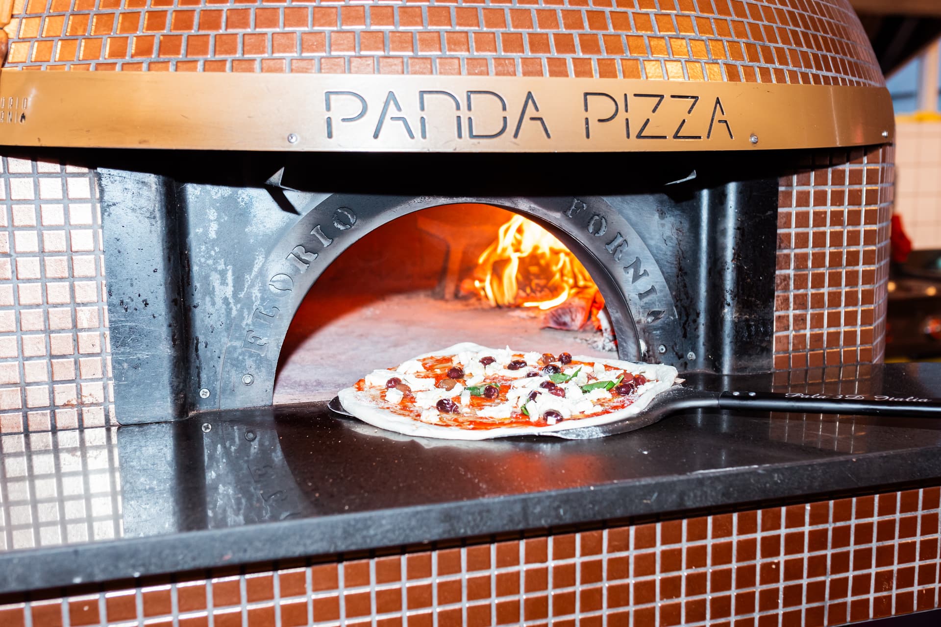 Pizza wordt in houtoven van Panda Pizza gedaan