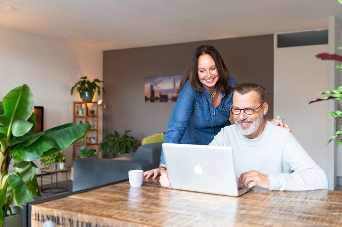 Man en vrouw kijken samen naar een laptop