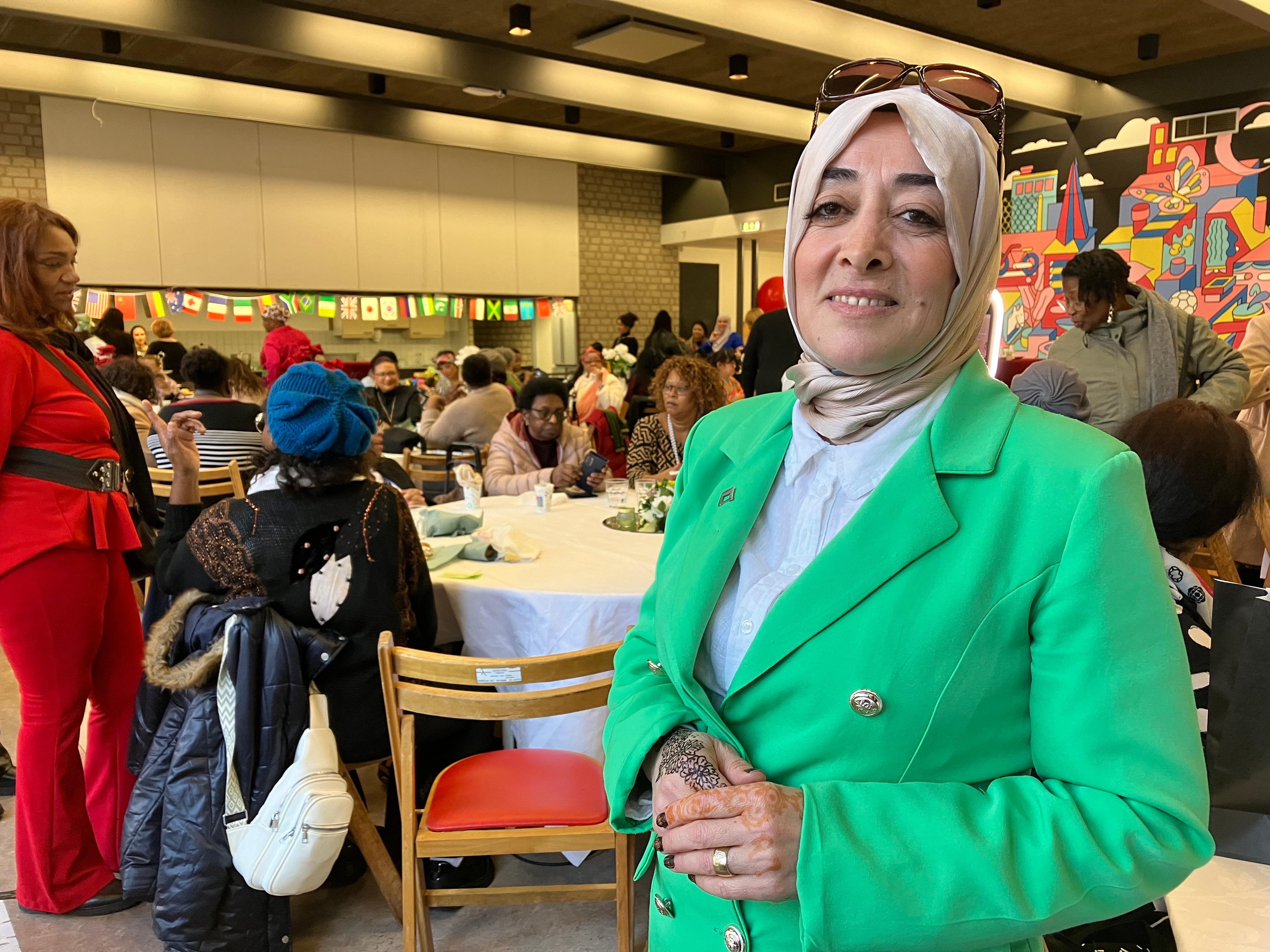 Aysel Tan op bewonersfeest in ruimte vol mensen