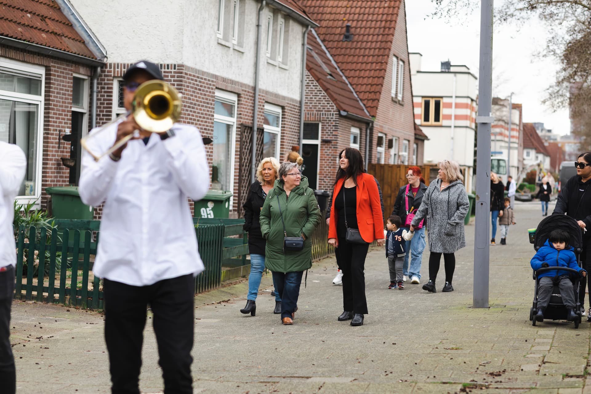 Bewoners en trompetspeler op straat, met bewoners op de achtergrond