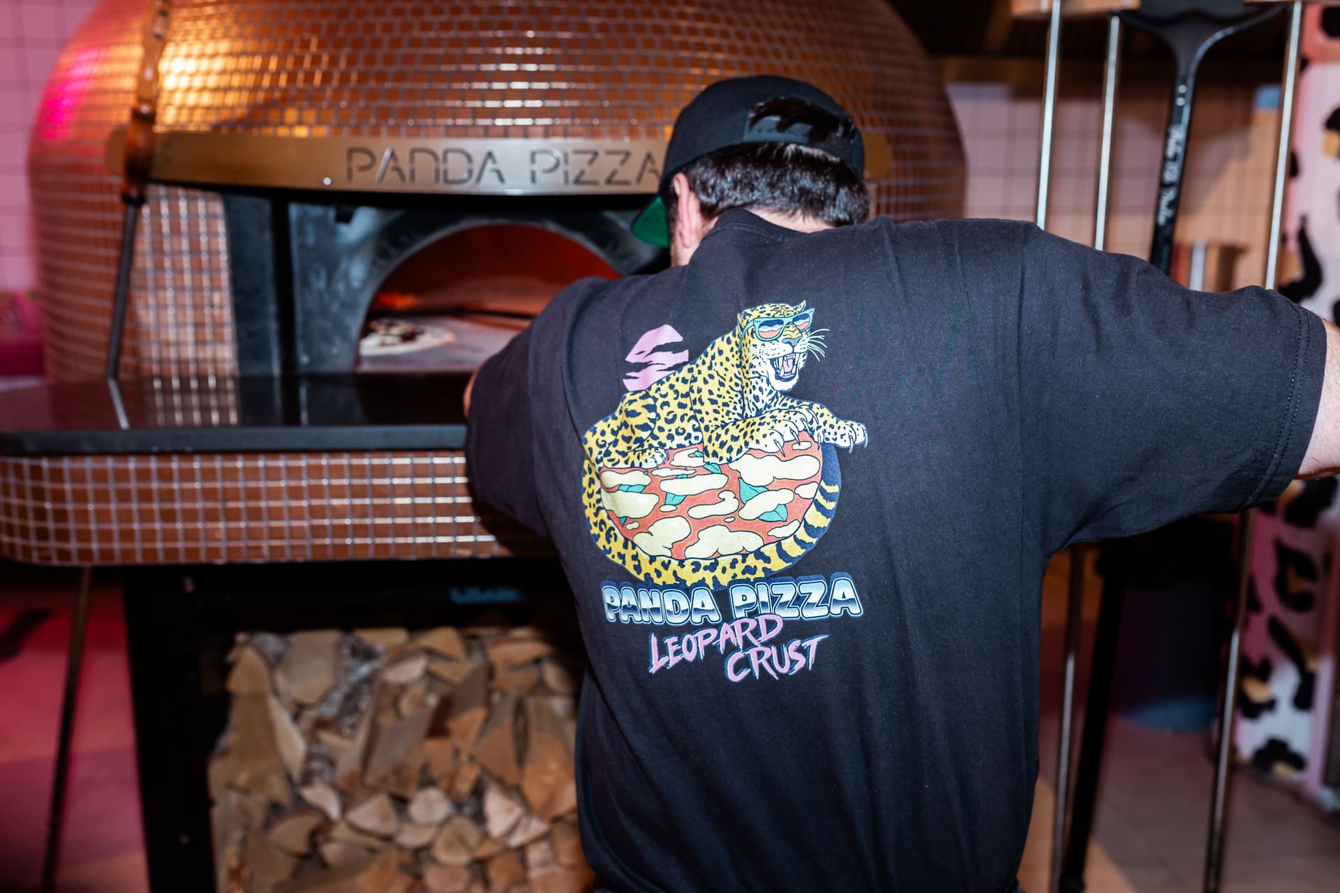 Pizzabakker schuift pizza in houtoven