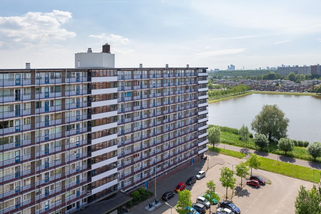Voorkant van de Prinsessenflats, van hoog gefotografeerd en met de skyline van Rotterdam op de achtergrond