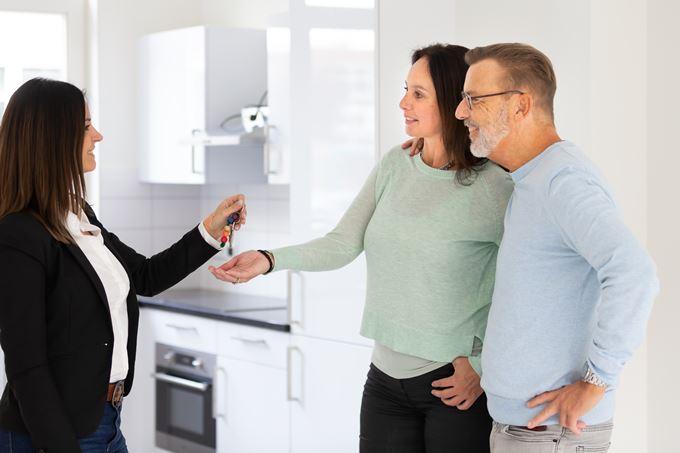 De makelaar overhandigt sleutels aan nieuwe bewoners