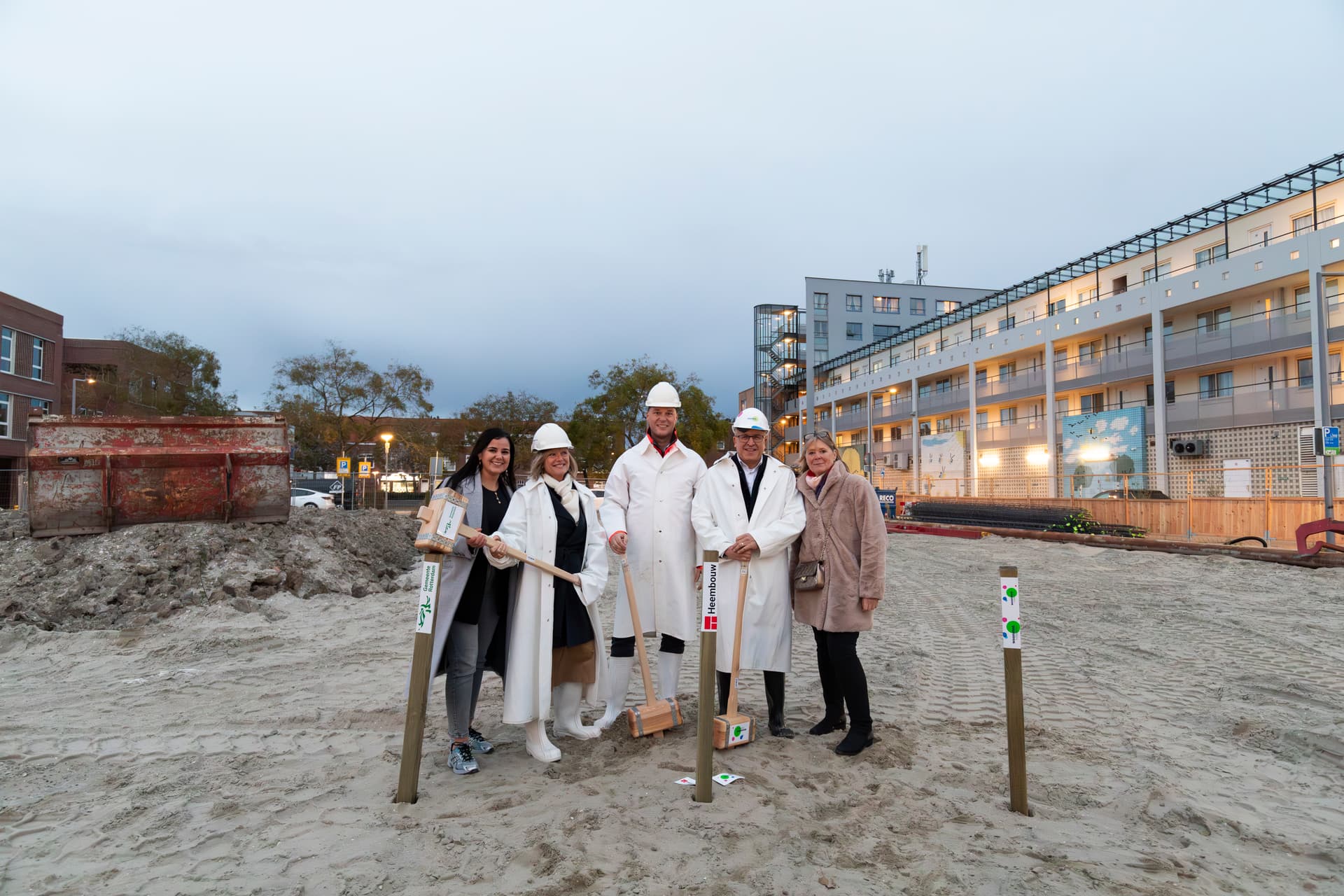 Groep mensen die aanwezig is bij het slaan van de eerste paal voor de nieuwbouw in Bloemhof