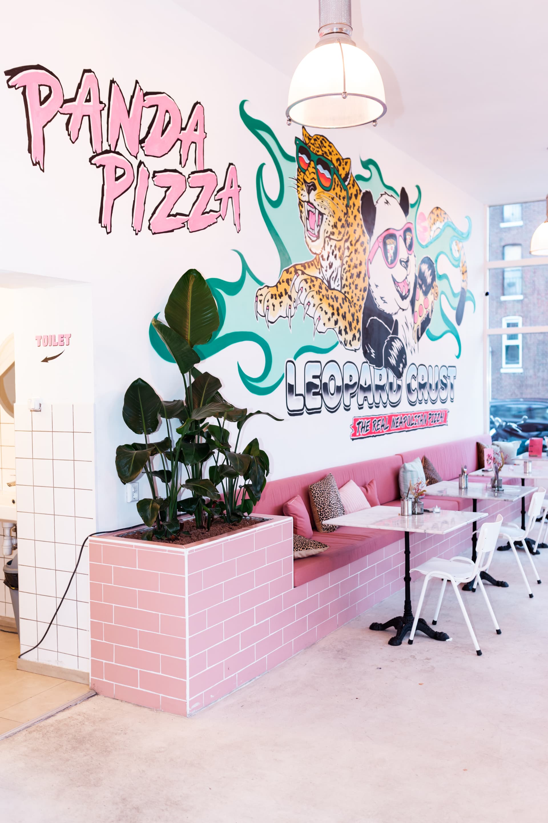 Roze interieur en muurschildering van Panda Pizza in Kralingen
