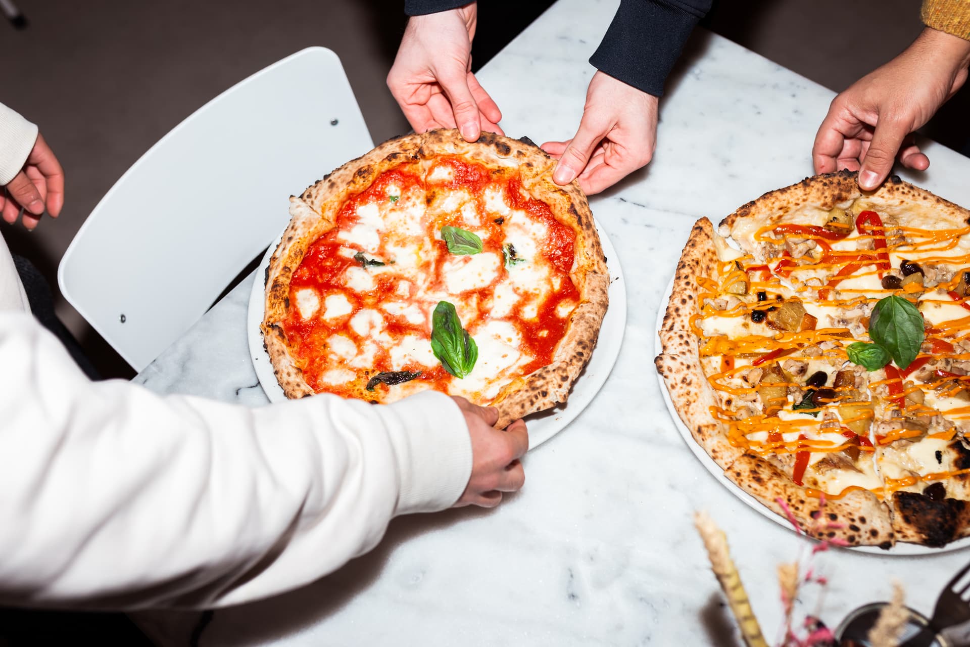 Handen pakken stukjes pizza