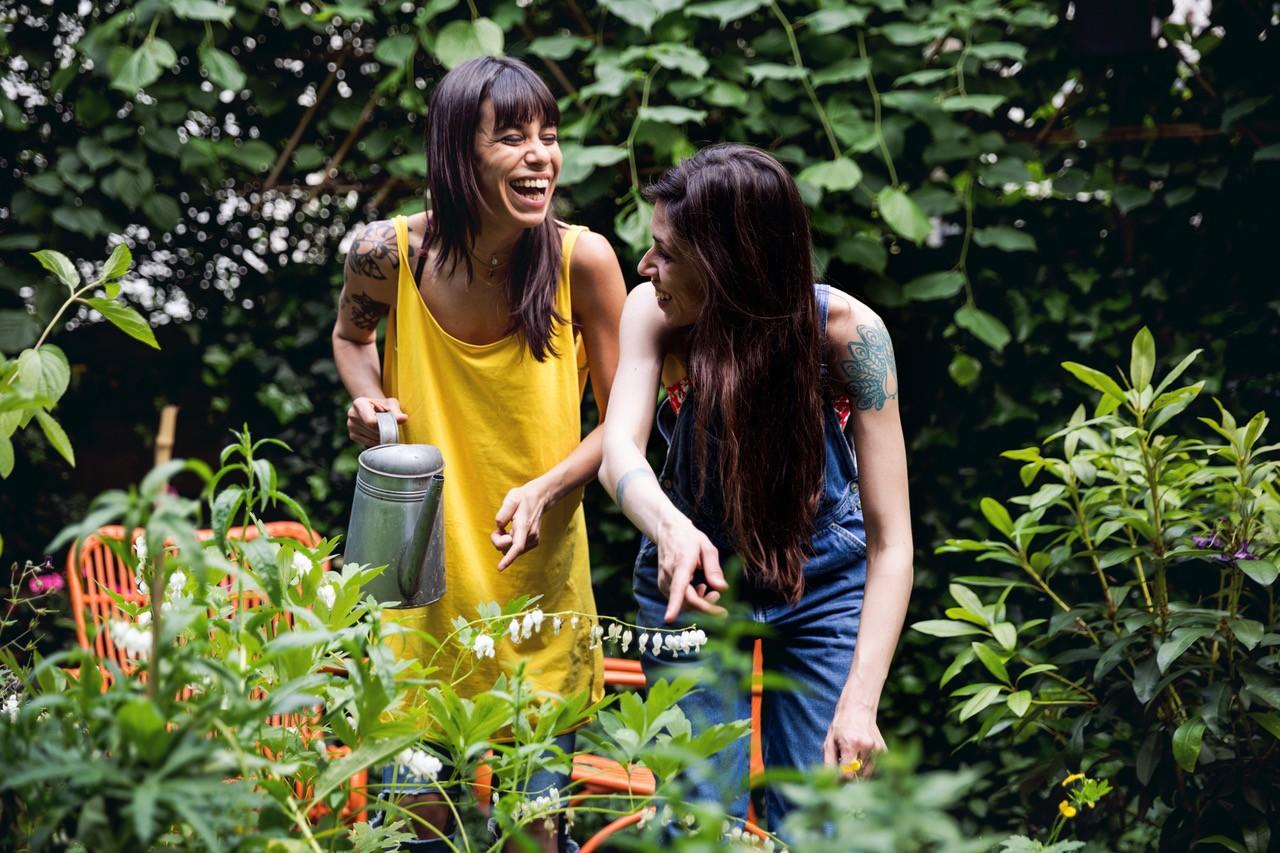 Twee vrouwen in een tuin met een gieter