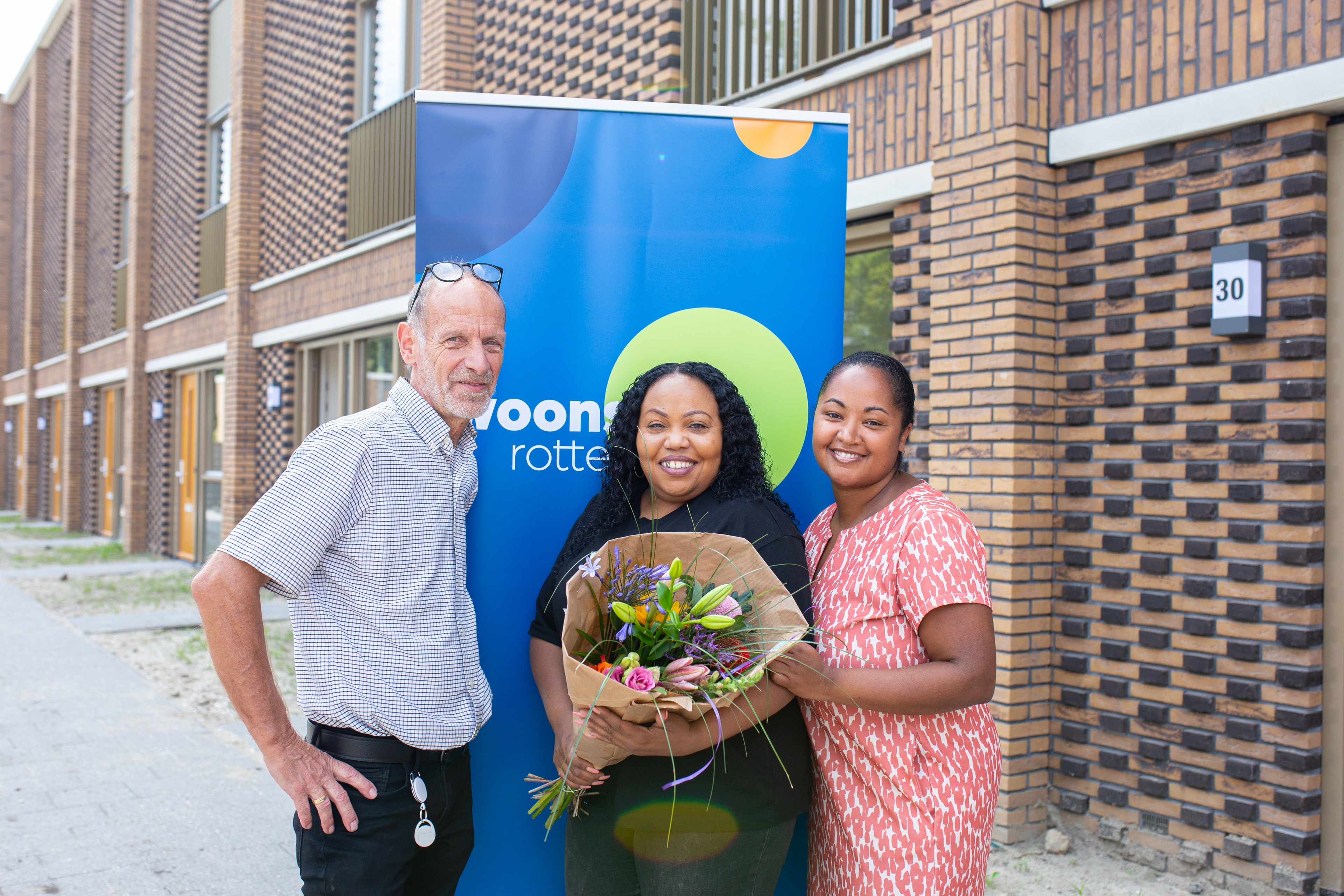Oplevering Halsterenstraat Pendrecht aardgasvrij groepsfoto met bos bloemen