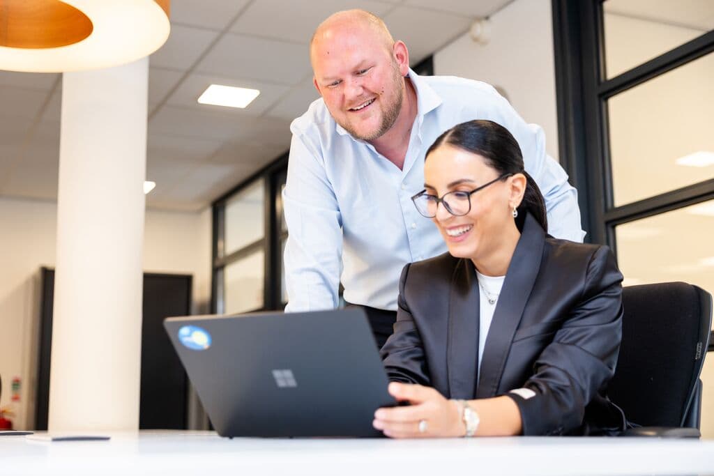 Een man en een vrouw kijken naar een laptop