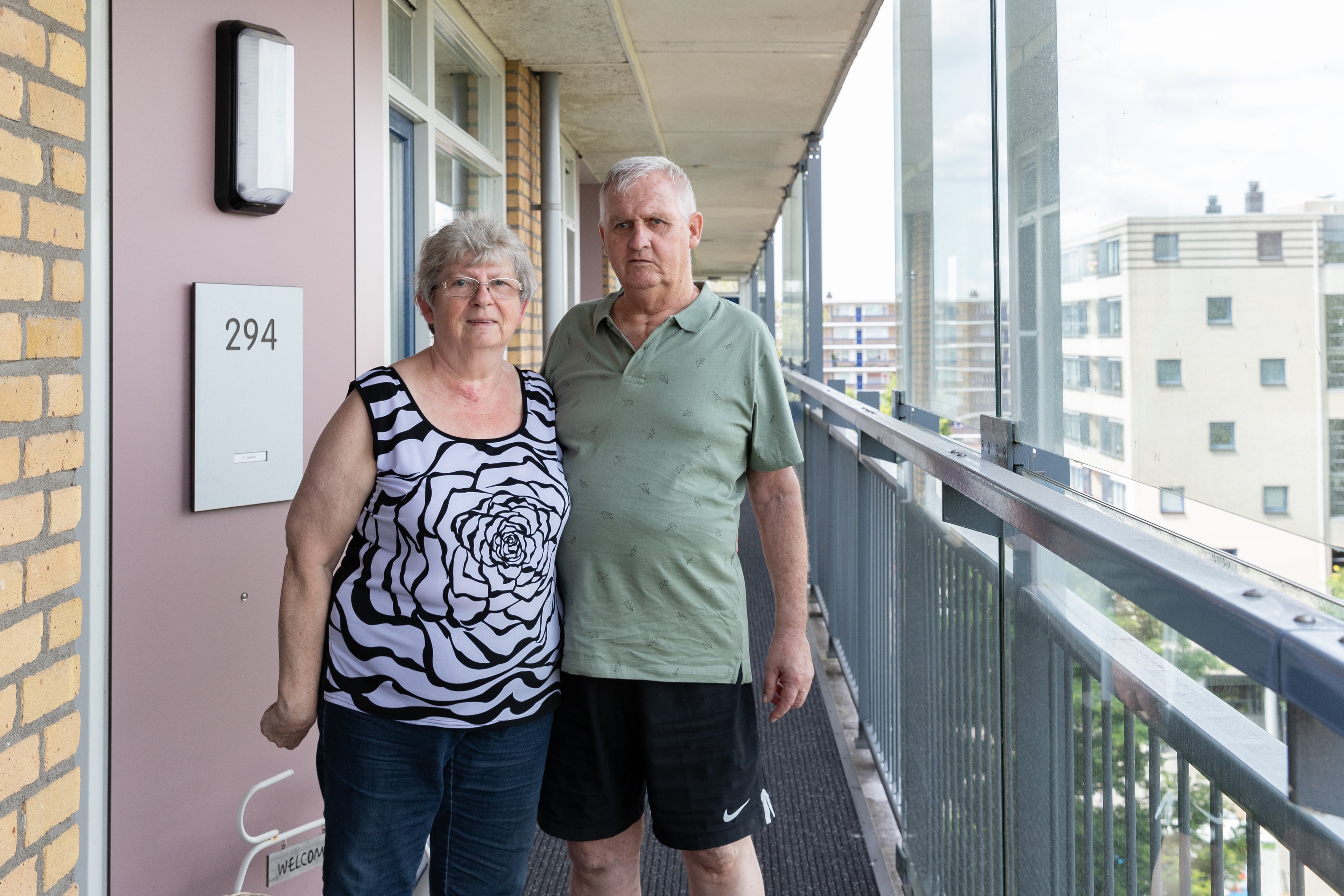 Mevrouw en meneer Zandvliet op de galerij voor hun flat