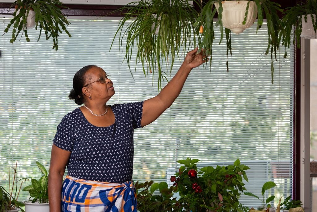 Mevrouw Kusten tussen de planten in haar woning