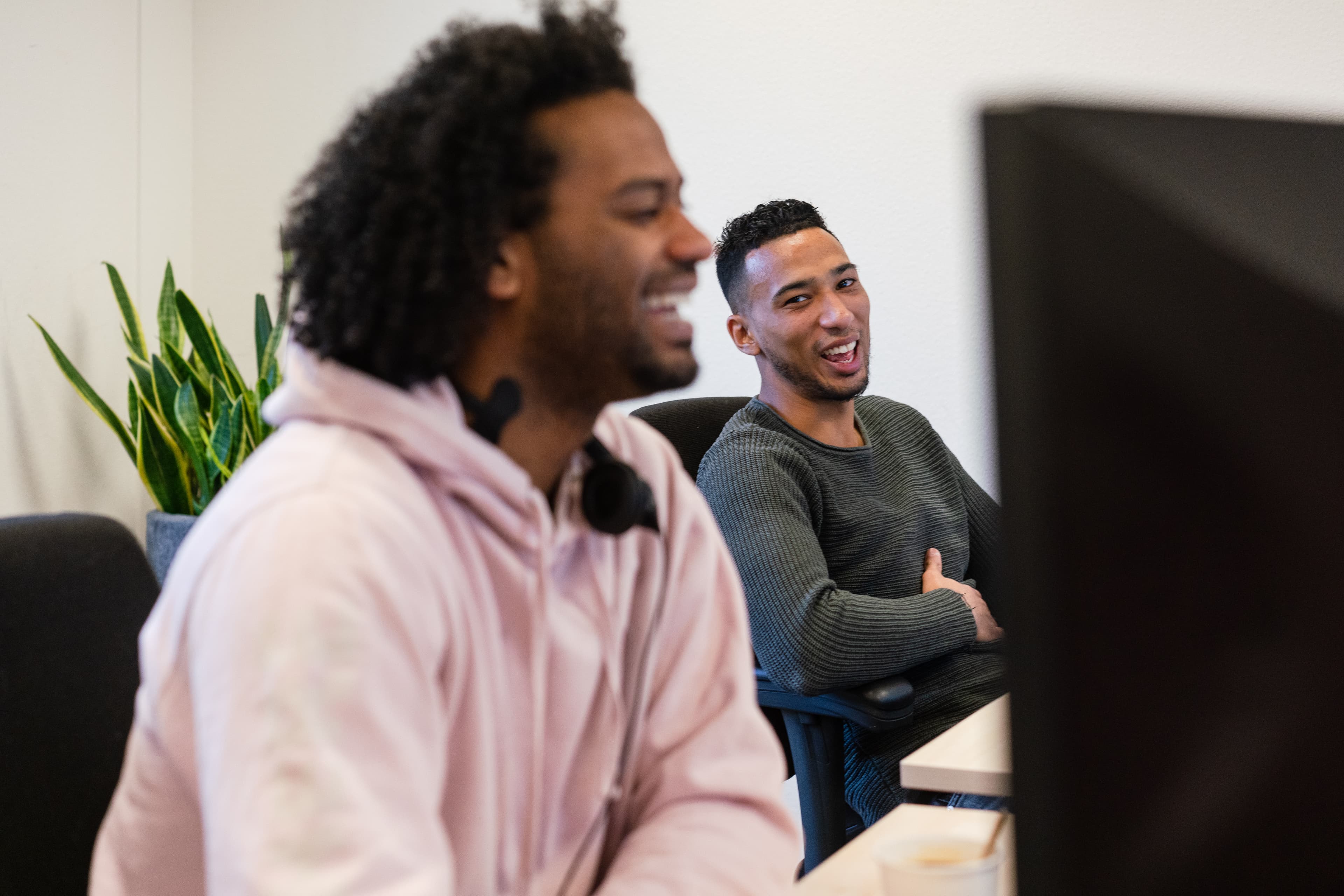 Twee mensen zitten naast elkaar met een headset