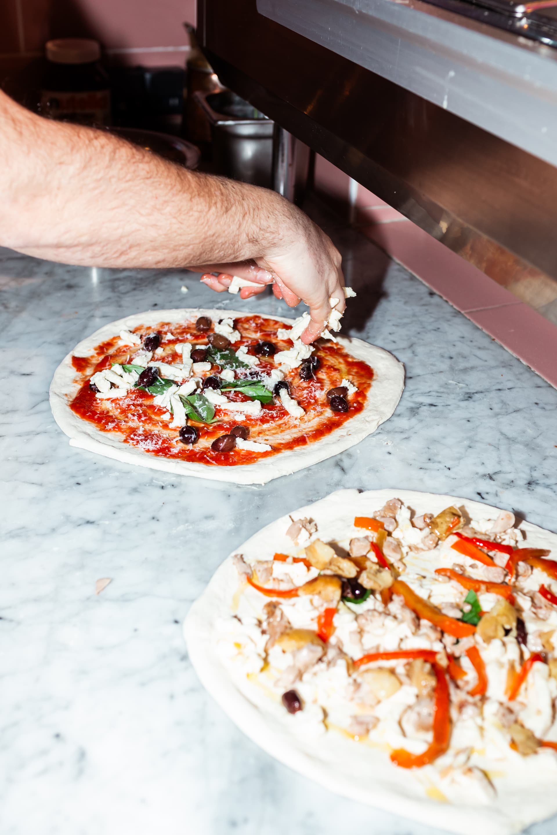 Twee pizza's die vers worden belegd