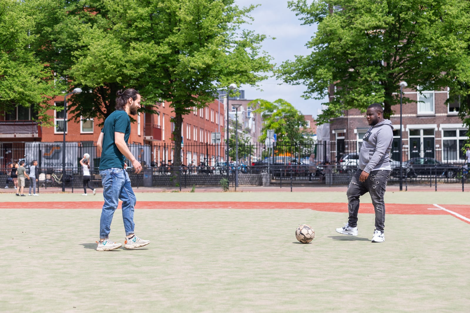 Ibraheem en man voetballen op veldje