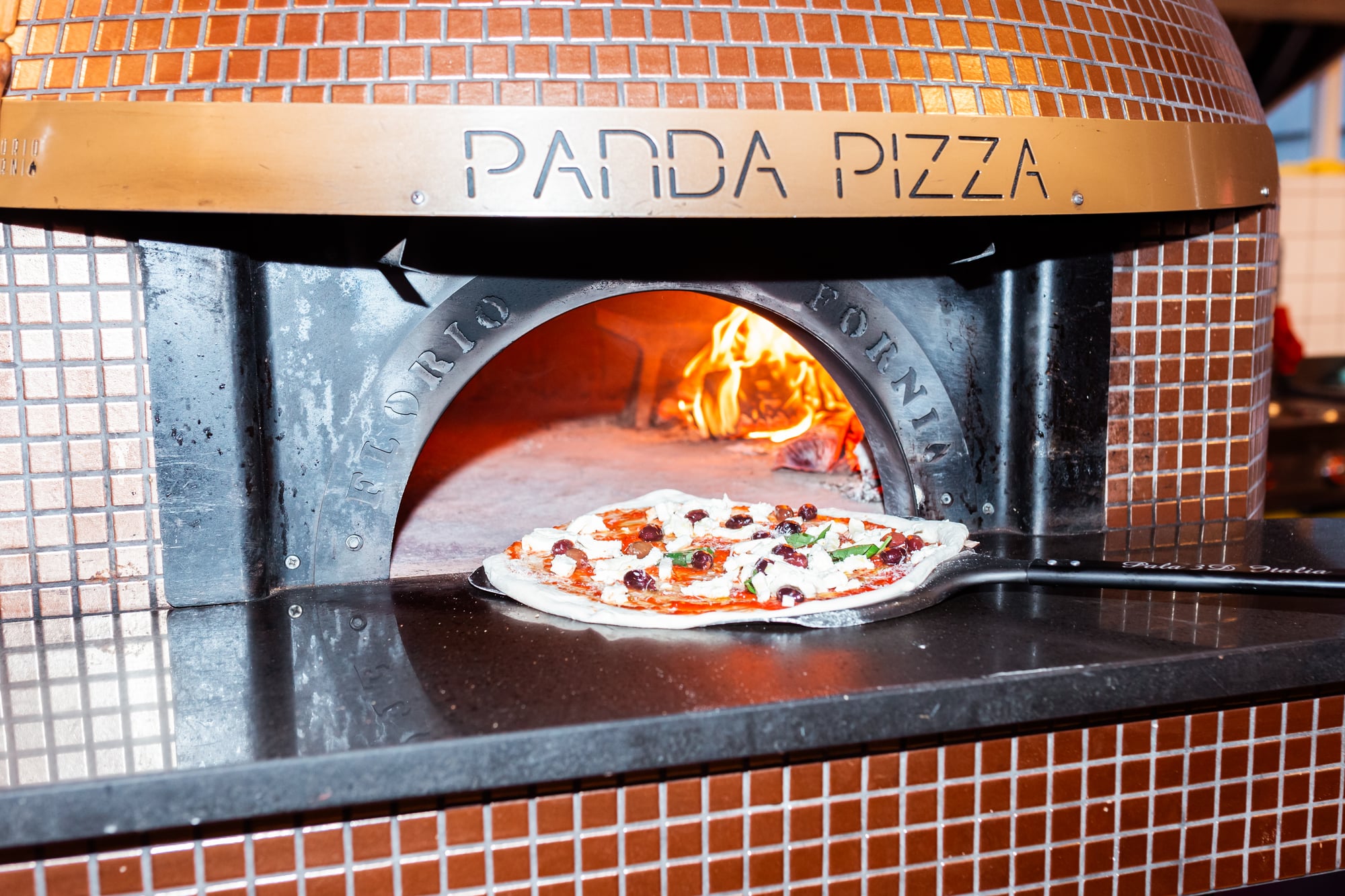 Pizza wordt in houtoven van Panda Pizza gedaan