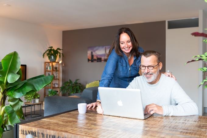 Man en vrouw kijken samen naar een laptop