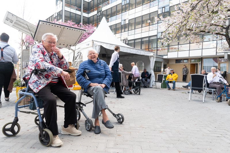 Twee oudere bewoners, zittend op rollators, bij de feestelijke heropening van de Korpersteijnflat