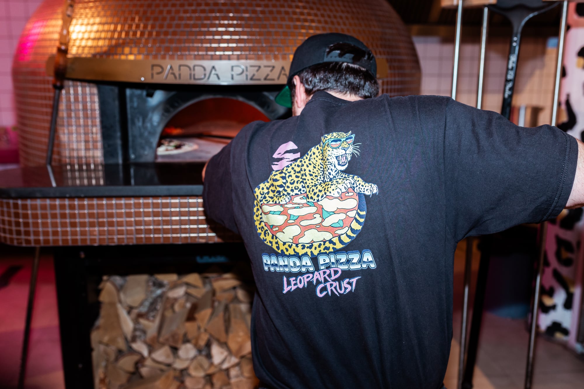 Pizzabakker schuift pizza in houtoven