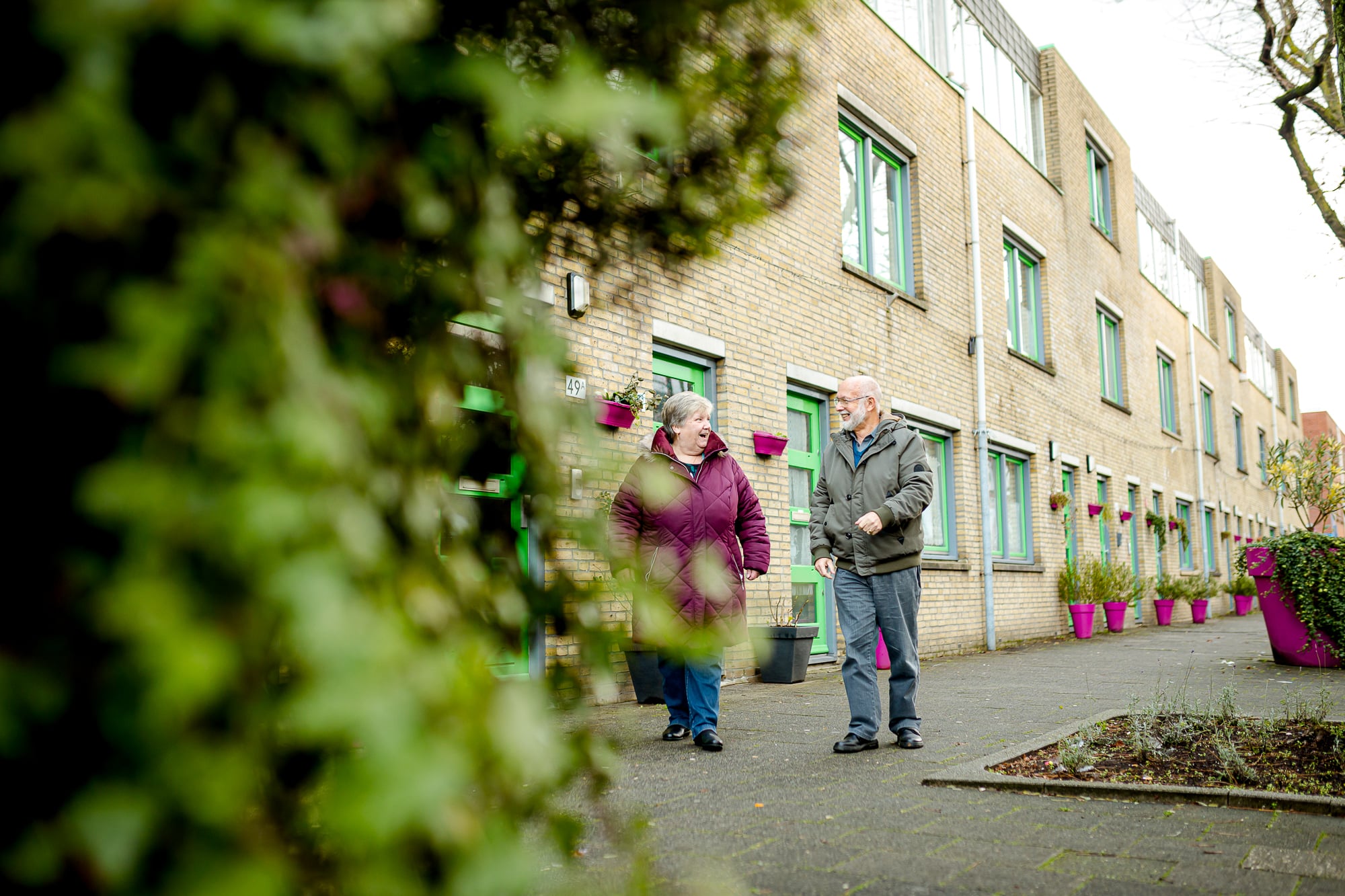 Mevrouw De Ronde en de heer Bornet lopen pratend over straat