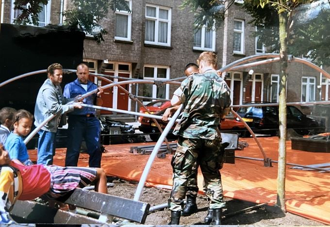 Soldaat en buurtbewoners zetten een tent op
