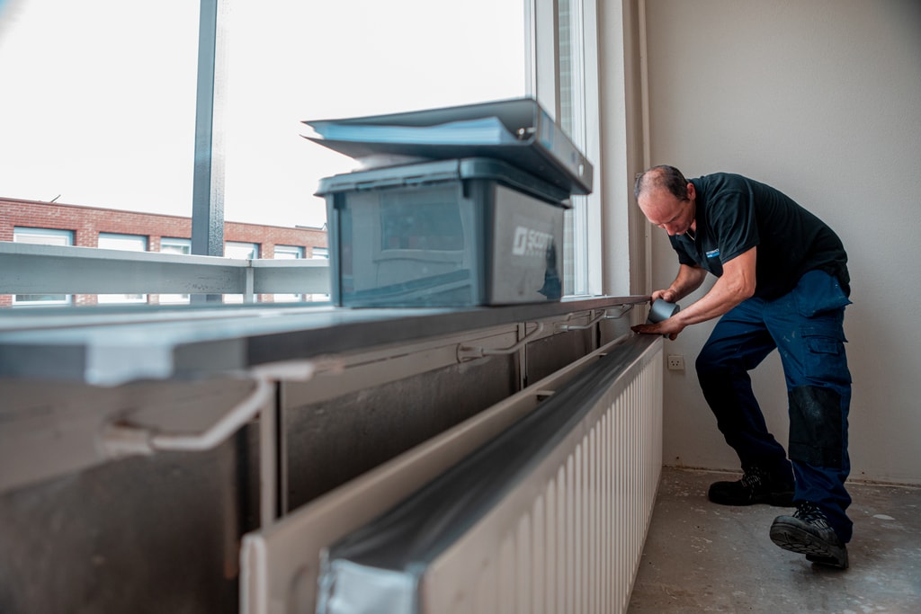 Man plakt duct tape op verwarming