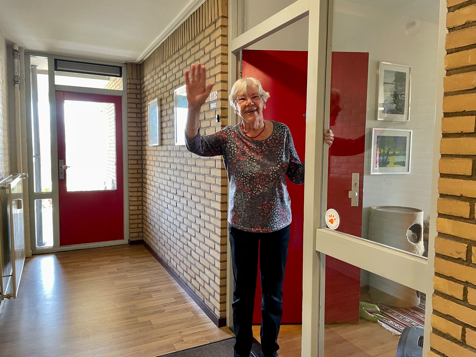 Ada Straatsma zwaaiend in deuropening thuisplusflat Leyerwaard