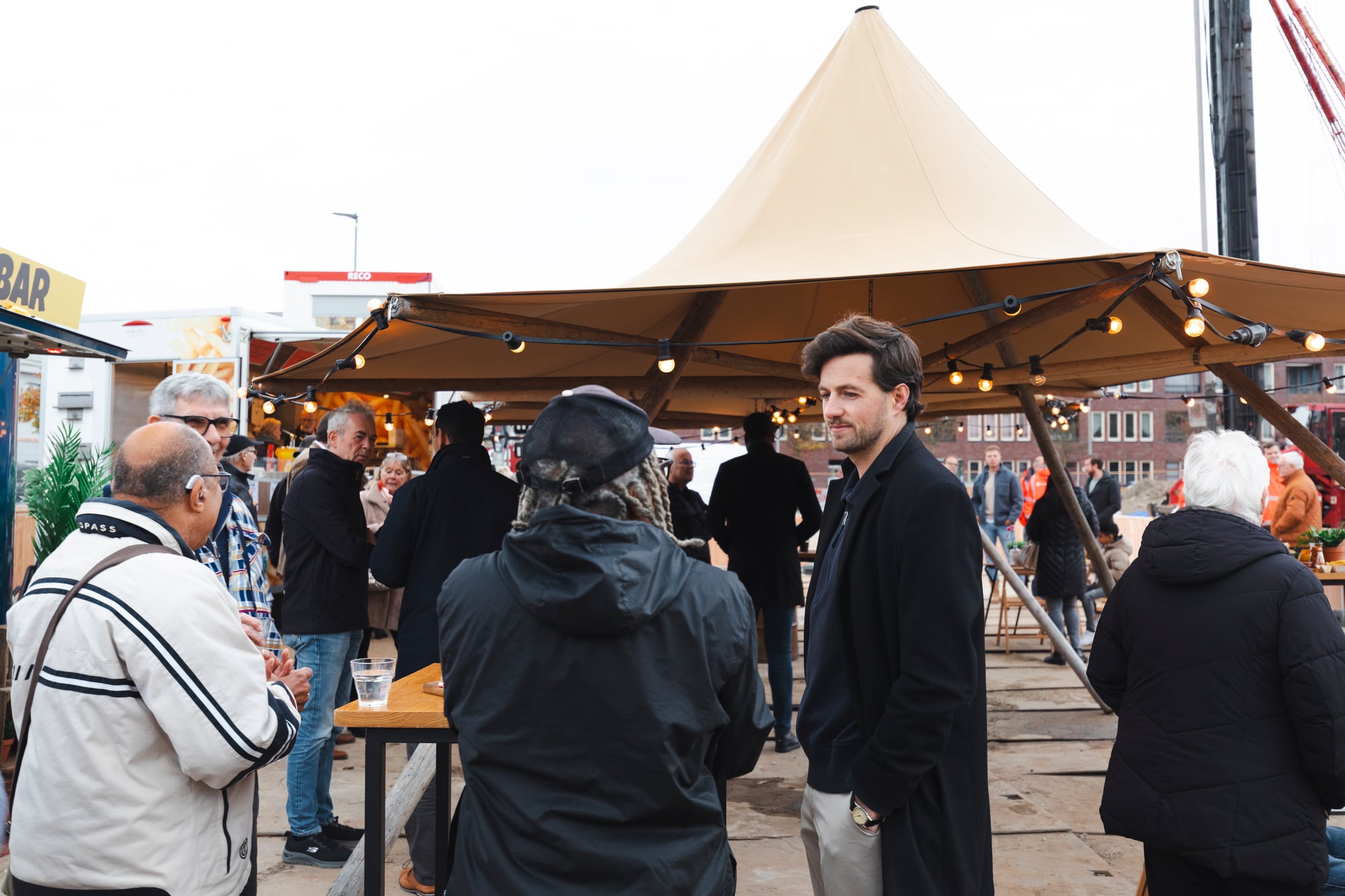Groep mensen die aanwezig is bij het slaan van de eerste paal voor de nieuwbouw in Bloemhof