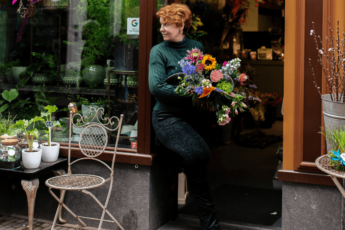 Elvira Hoogerwerf in deuropening met bos bloemen