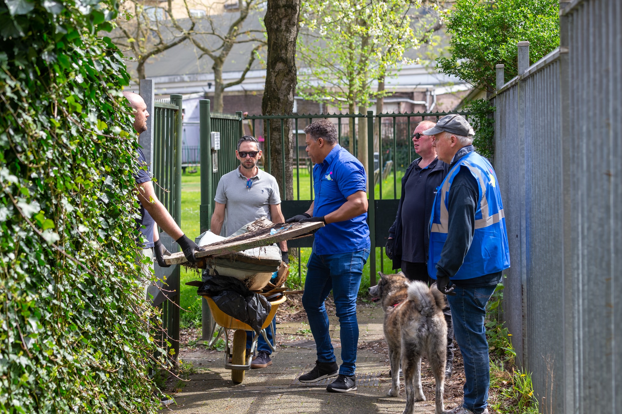 Mannen met kruiwagen halen troep op