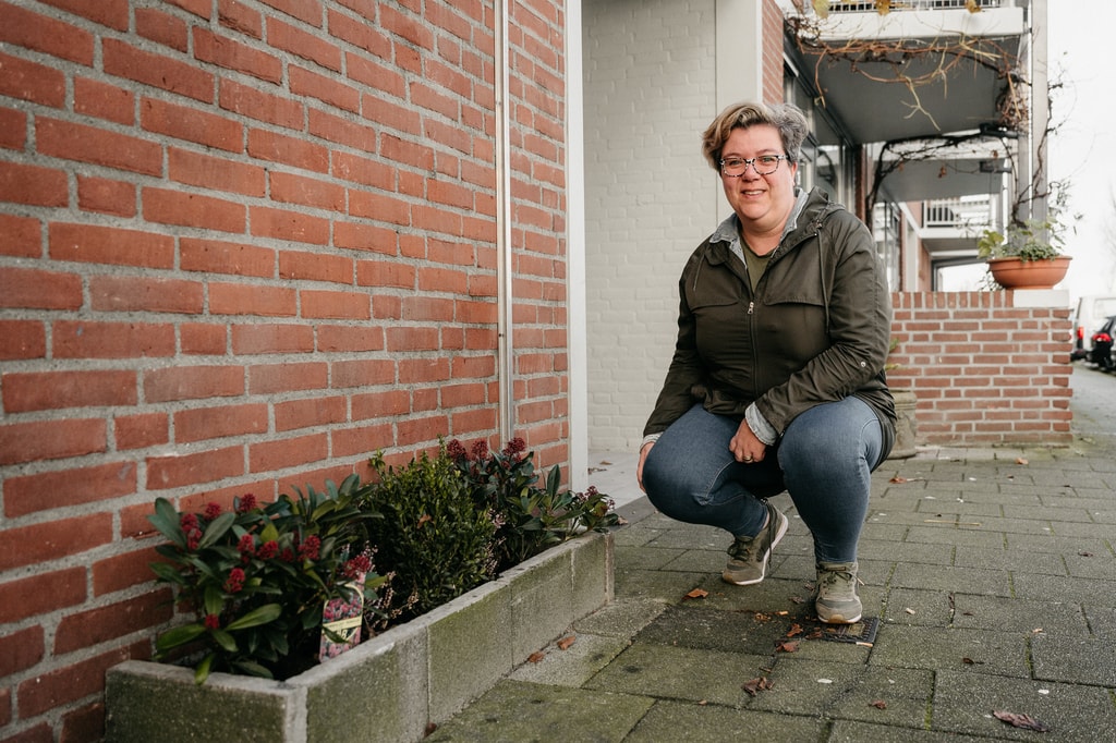 Karin van der Bilt hurkt naast geveltuin