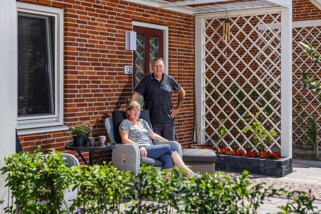 Man en vrouw in de voortuin van hun woning