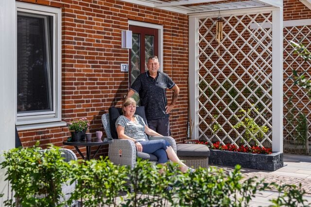 Man en vrouw in de voortuin van hun woning