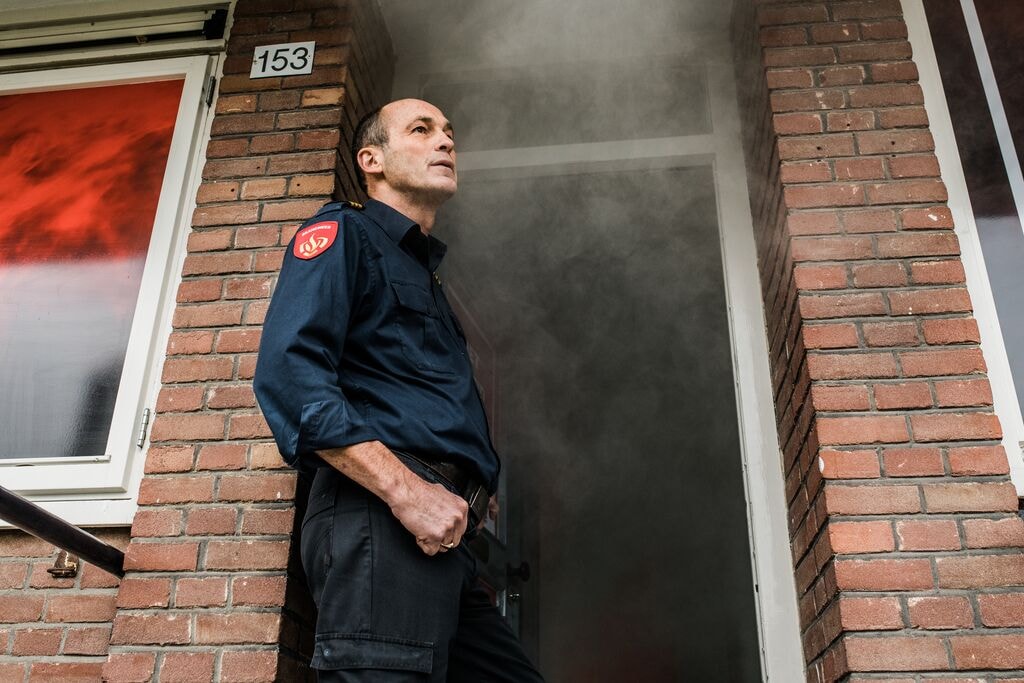 Brandweerman in de deuropening van een woning