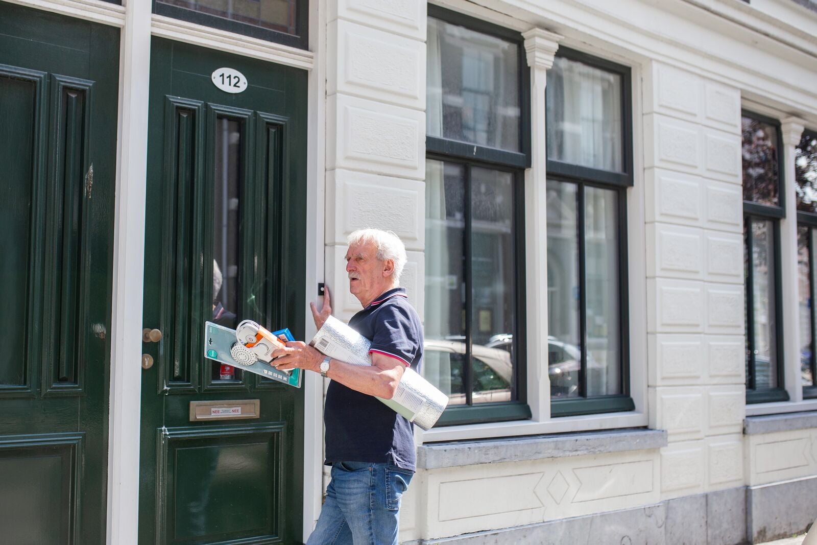 Energiecoach Rob van der Meulen belt aan met materialen in handen