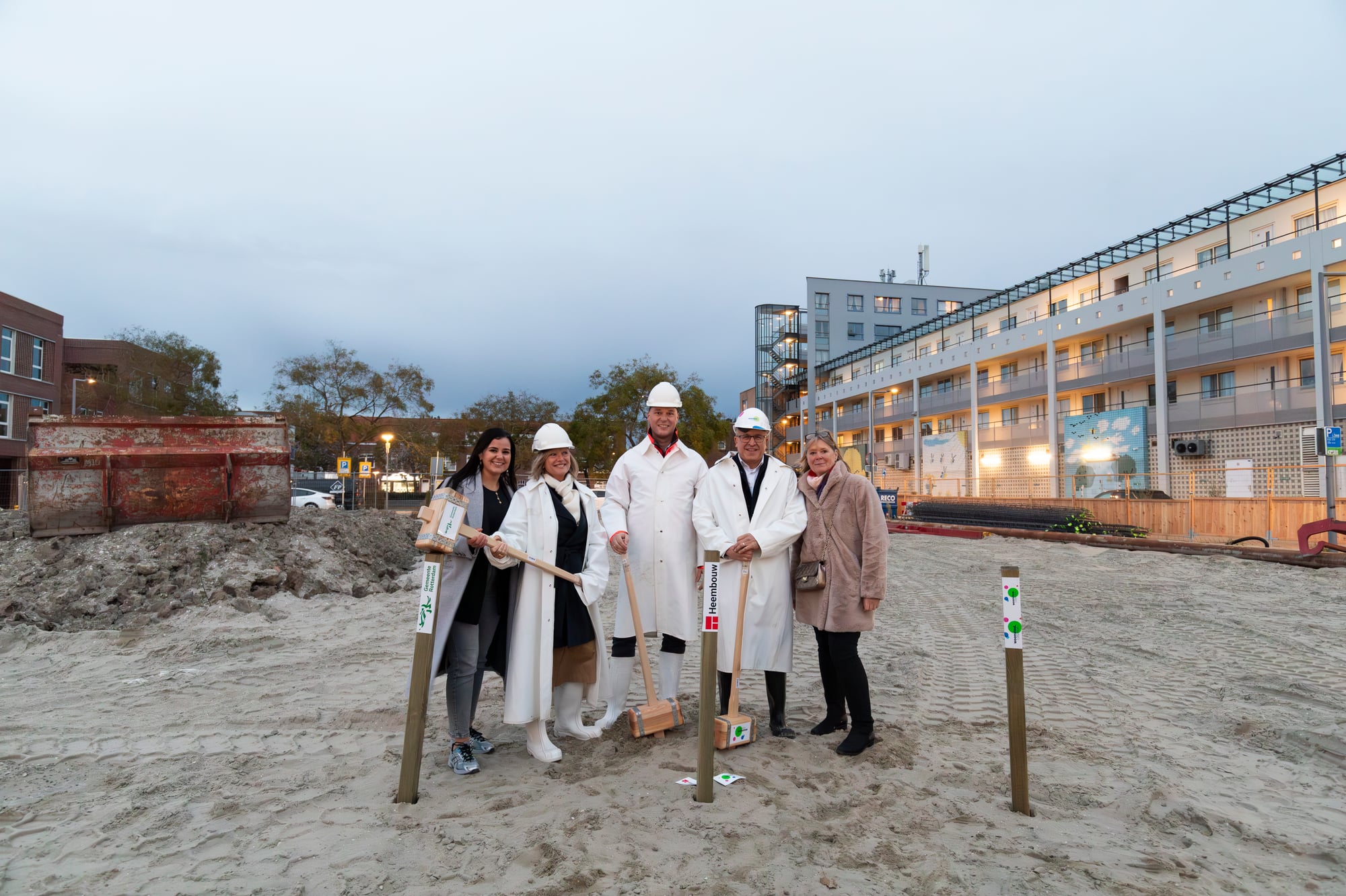 Groep mensen die aanwezig is bij het slaan van de eerste paal voor de nieuwbouw in Bloemhof