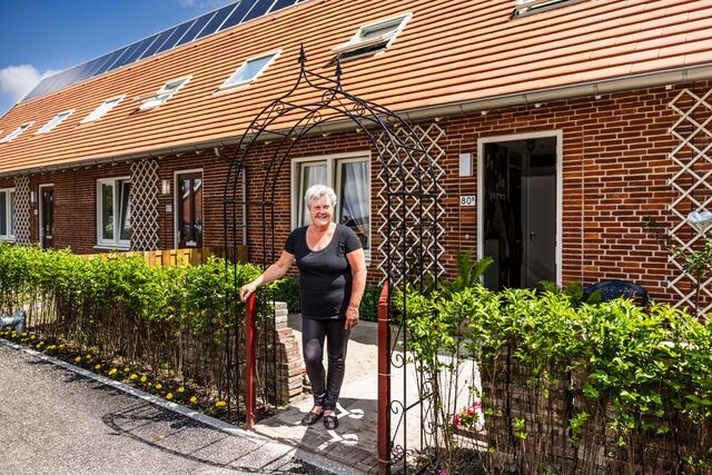 Bewoner lachend in haar voortuin