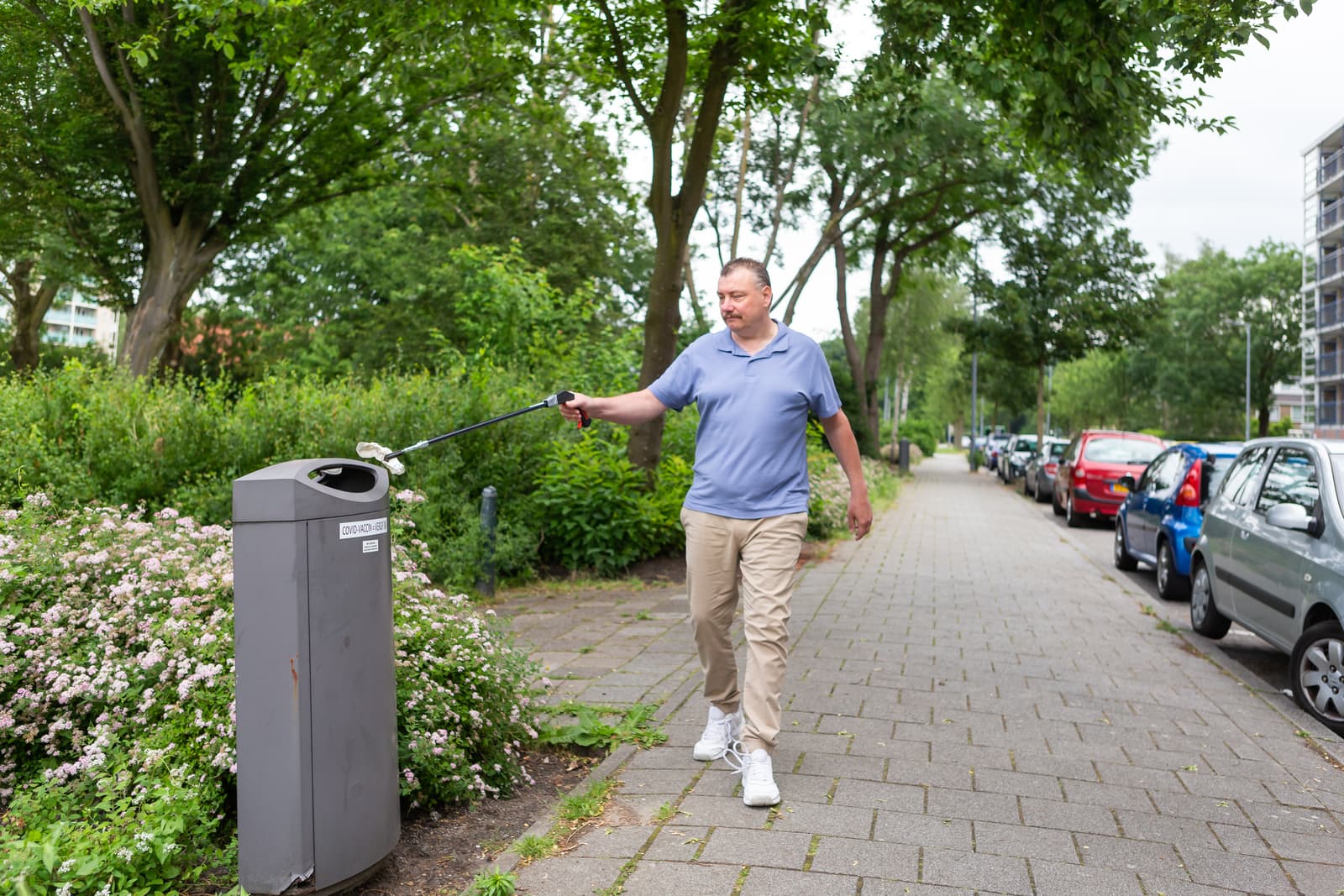 Herman raapt vuil op straat op met knijper