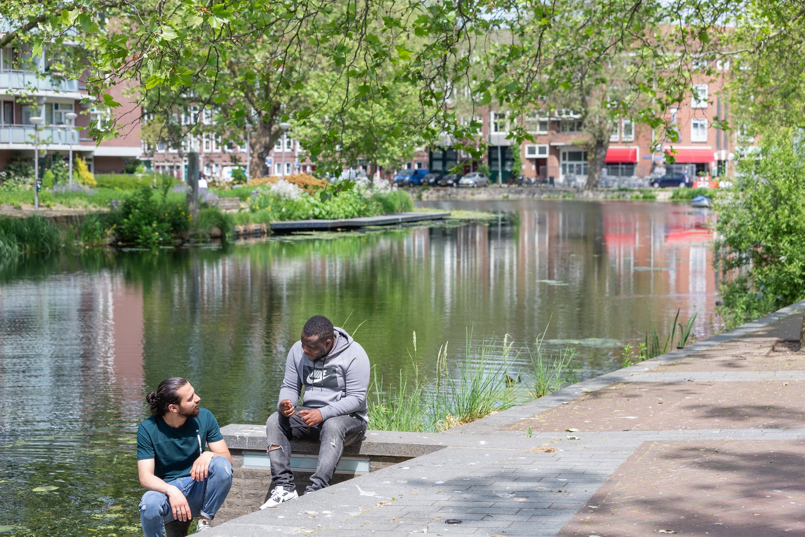Ibraheem en man zittend aan de waterkant