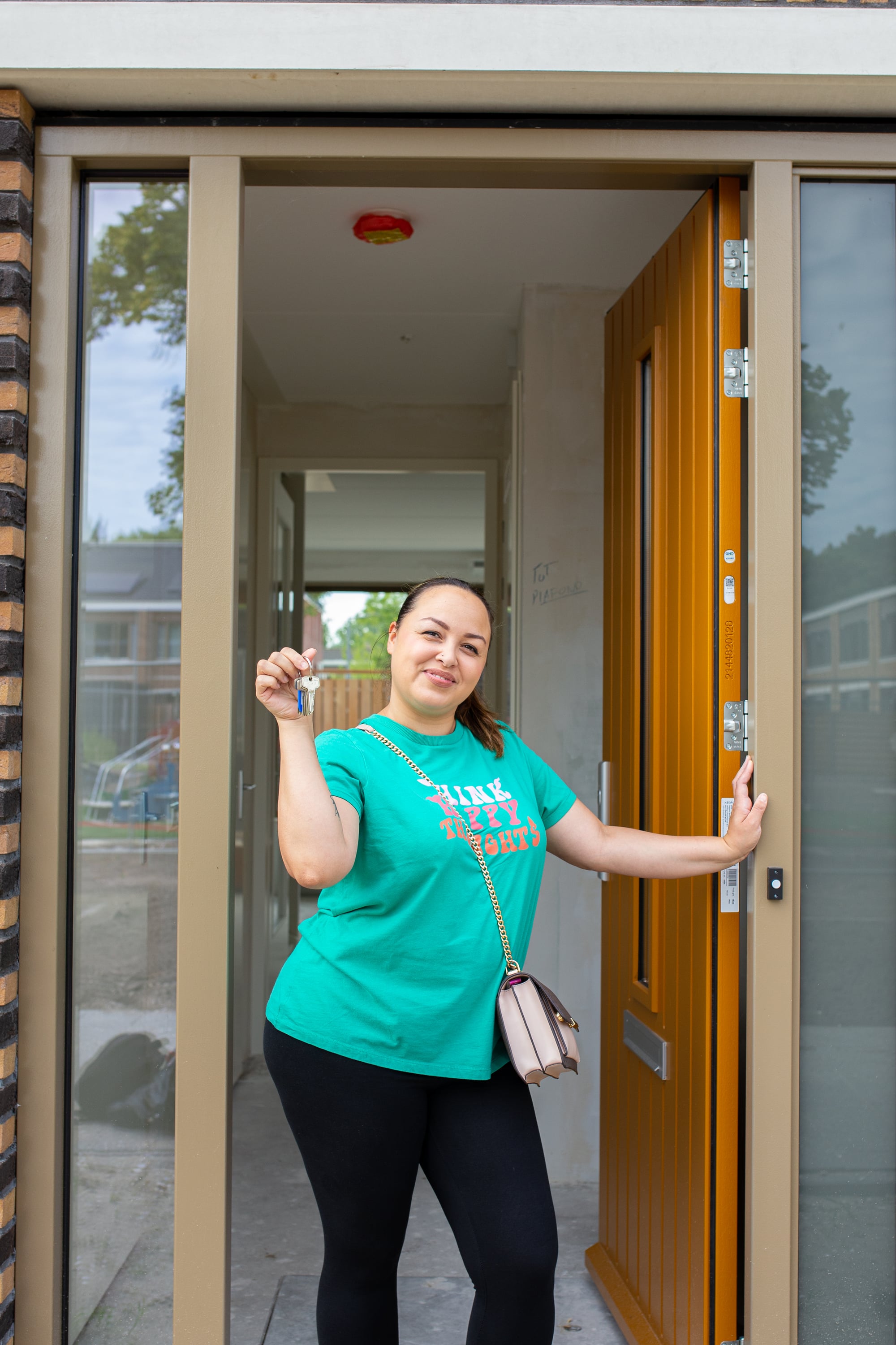 Oplevering Halsterenstraat Pendrecht aardgasvrij vrouwelijke bewoner voor deur