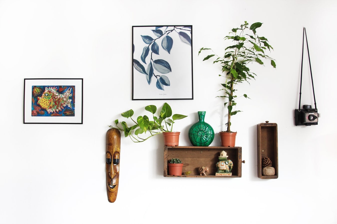 Muur vol met decoraties, fotolijstjes en planten