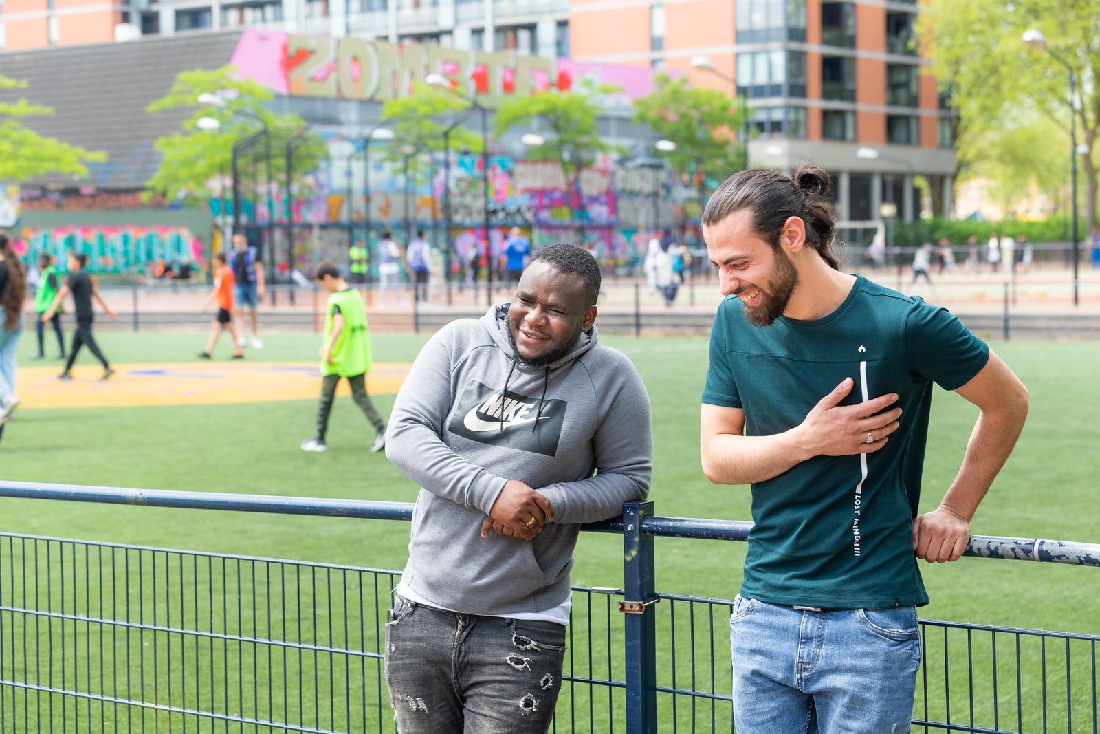 Ibraheem en man naast hek bij het voetbalveld