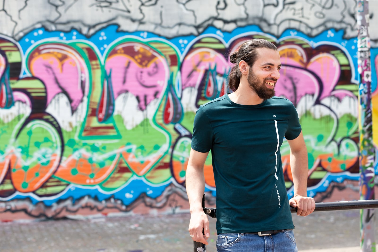 Ibraheem voor een muur met graffiti