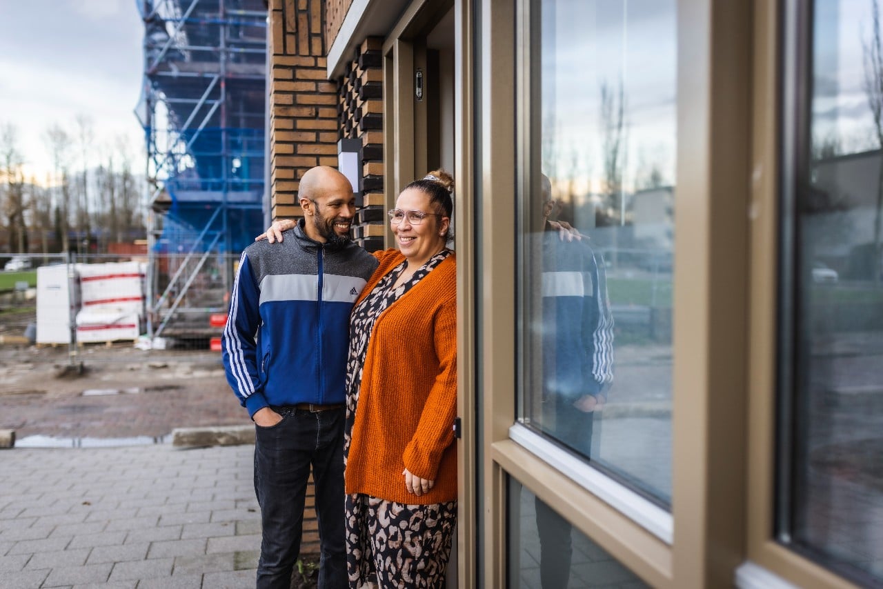 Ninny en Francisco in de deuropening van hun nieuwbouwwoning in Pendrecht